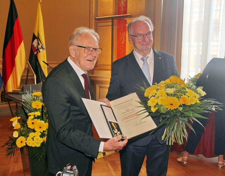 Täve Schur und Ministerpräsident Dr. Reiner Haseloff mit Verdienstorden, Urkunde und Blumenstrauß