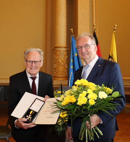 Täve Schur und Ministerpräsident Dr. Reiner Haseloff mit Urkunde und Blumenstrauß