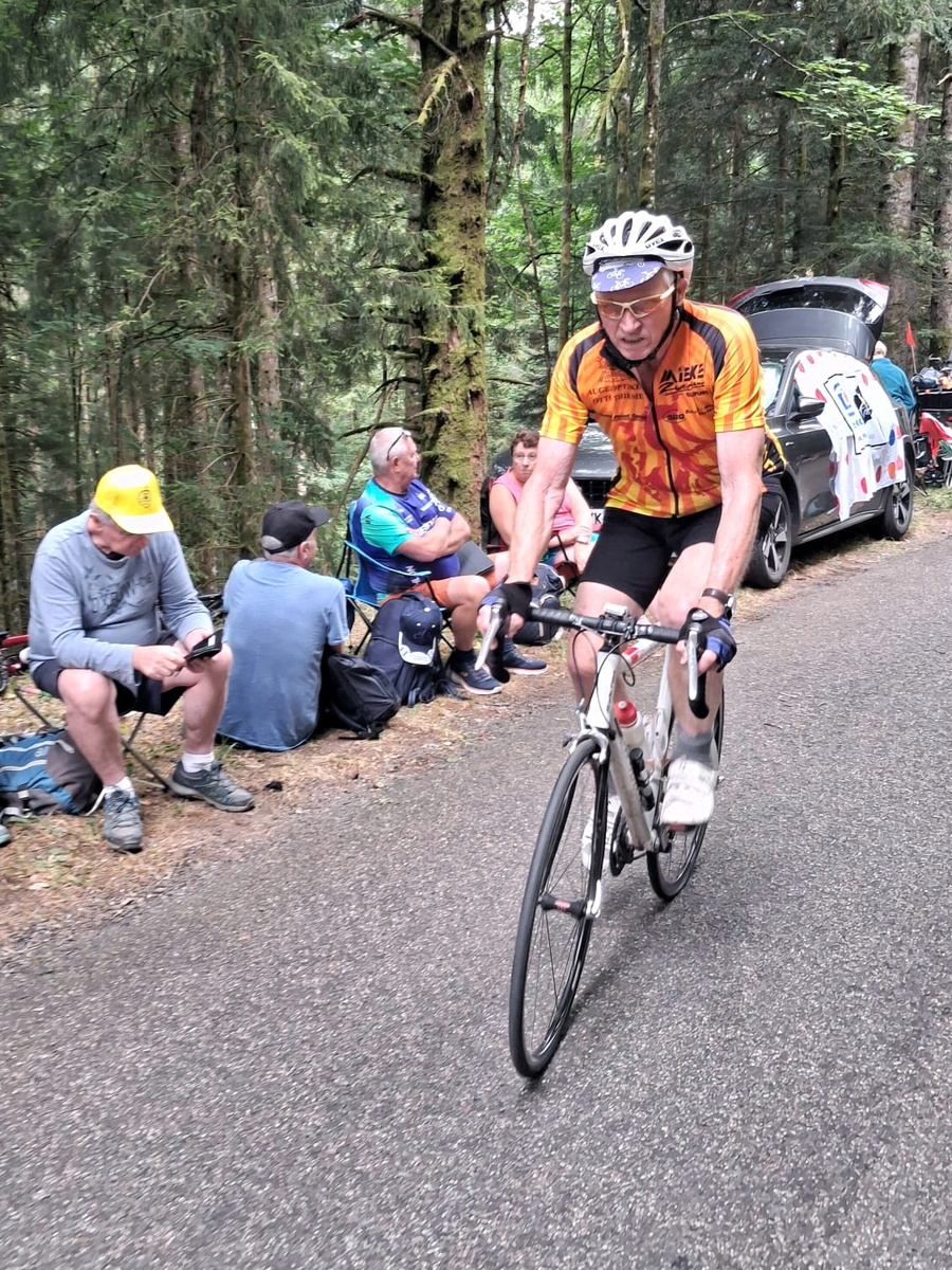 Radfahrer im orangefarbenen Trikot bei der Auffahrt zur Côte du Page in den Vogesen