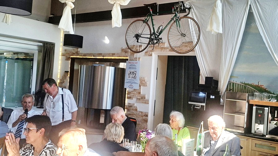 Gruppe von Männern im Gespräch an einem Tisch im Freien